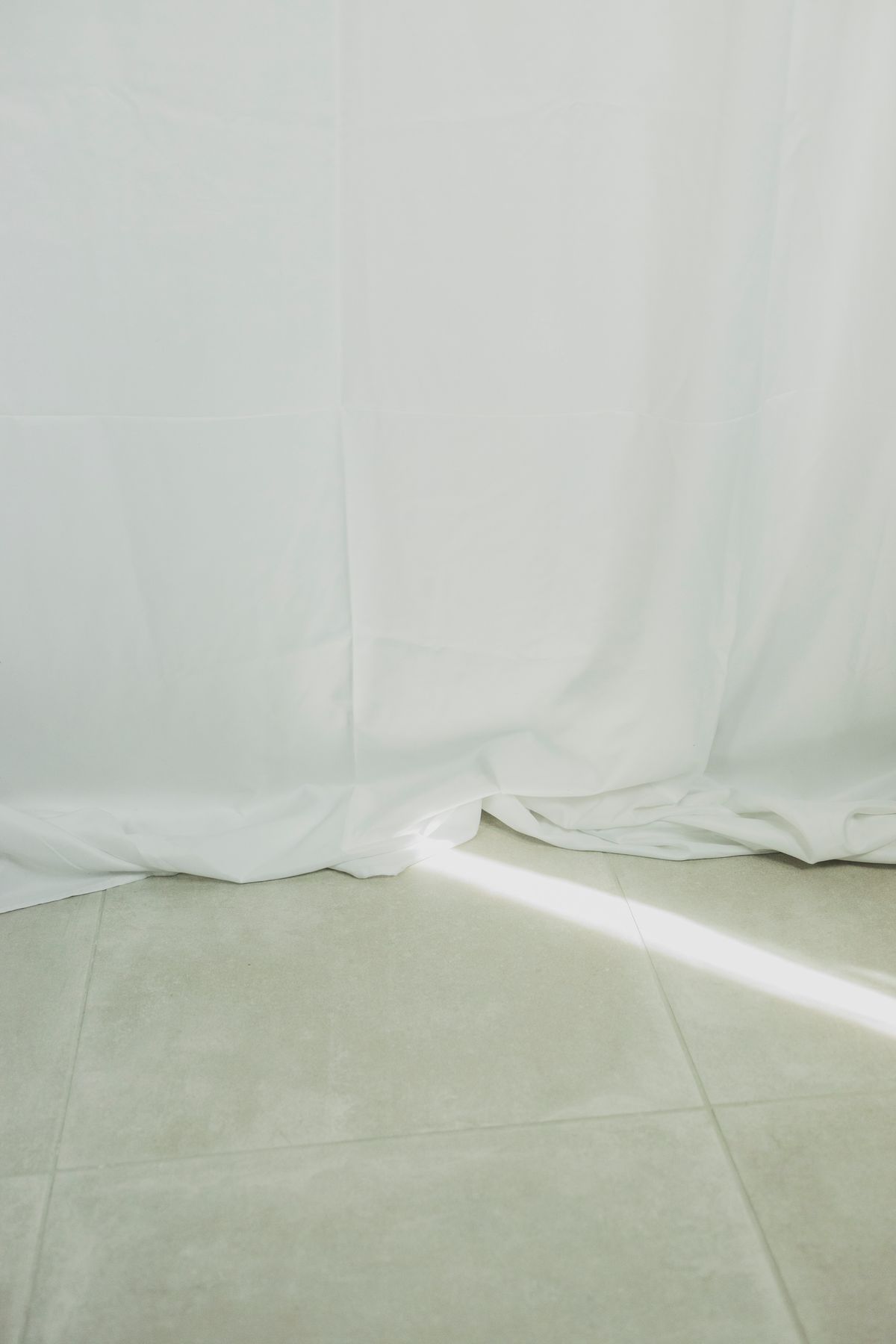 White curtains beside a tiled floor