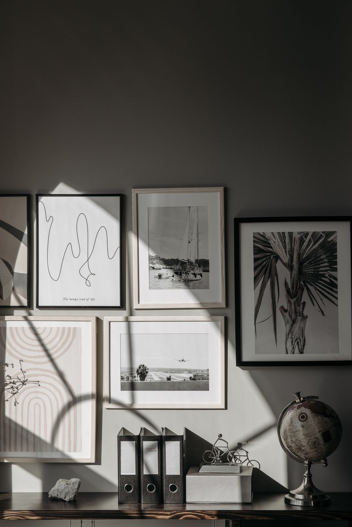 Arrangement of framed pictures and objects above a console