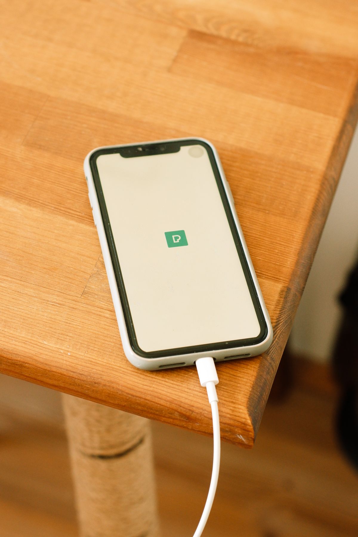 Phone connected to a charger on a table