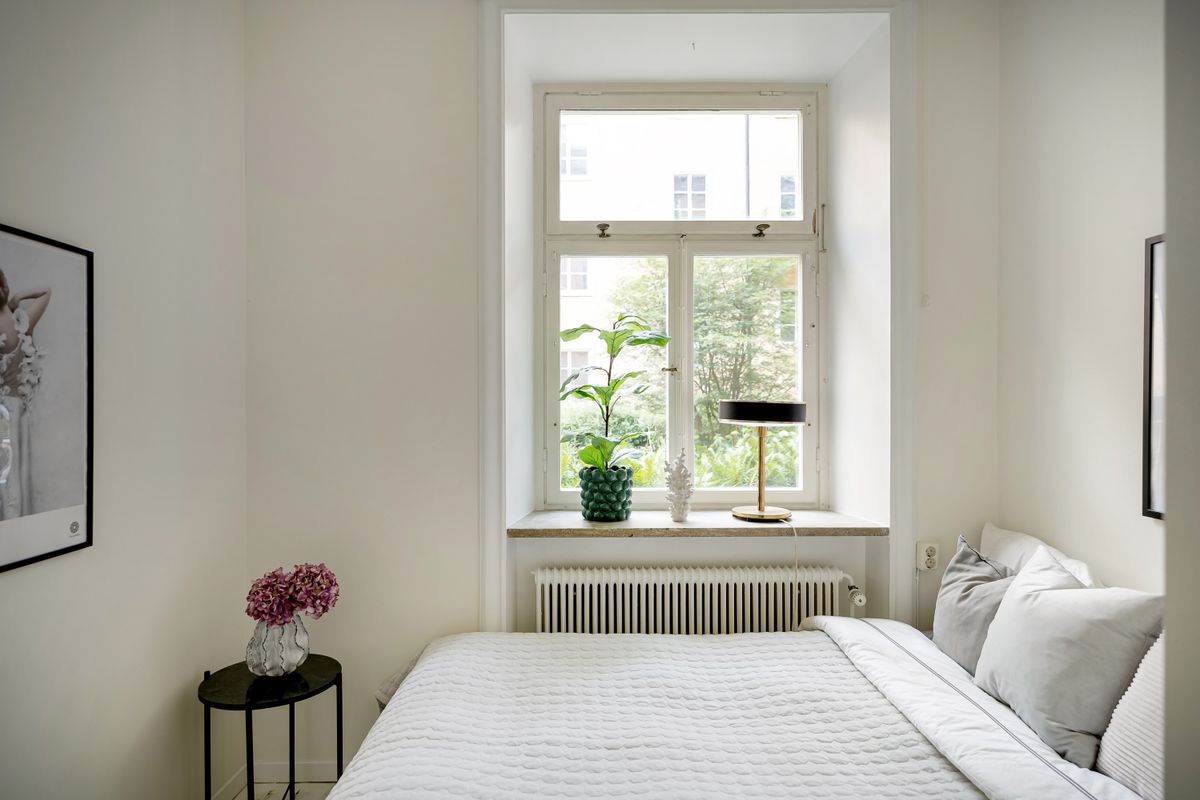 Small bedroom with a bed beside a window