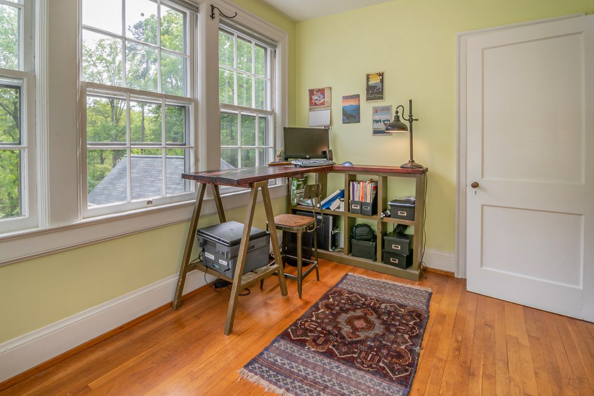 Wooden desk beside windows in a corner