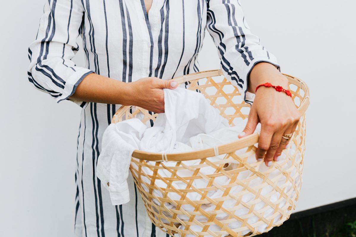 A person holds a basket of laundry