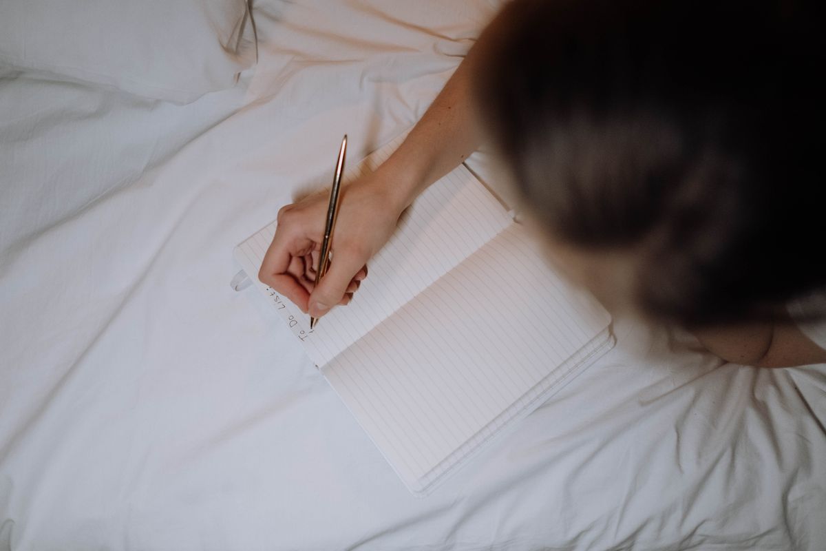 A person writes a list in a notebook